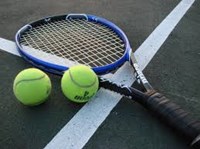 tennis racket and tennis balls laying on a tennis court