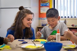 student painting with teacher