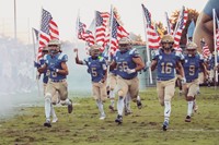 Clovis High FB carrying flags