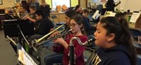 Photo of students playing instruments during a practice session.