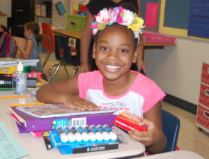 Girl Sitting at Desk with School Supplies