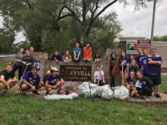 Students posing by Welcome to Caseyville sign