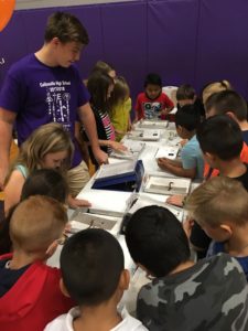 Children around table looking at science display