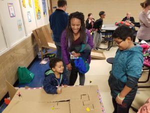 Children playing board game made out of cardboard