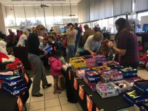 Children picking out news shoes from a large table