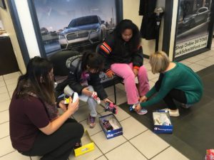 Girls being fitted for new shoes