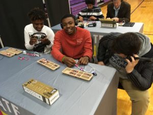 Boys work to build a synthesizer out of circuits