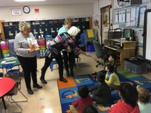 Delta Epsilon members give books to students