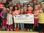 PreK students holding giant check from Sunrise Kiwanis