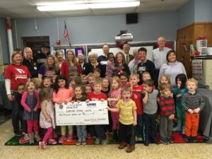 Members of Sunrise Kiwanis Club posing with students and check