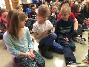 children examining a piece of coal