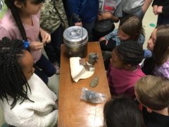 children looking at coal miner's personal supplies