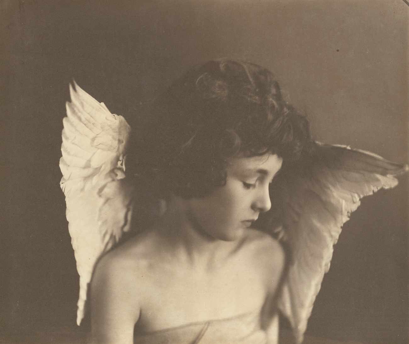 A young child with tousled hair and wings