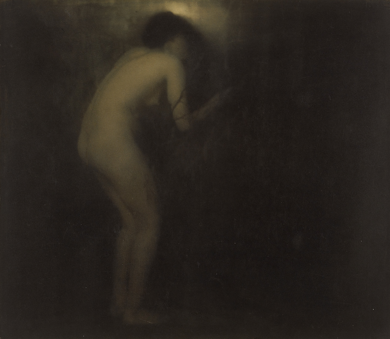 Nude woman crouches by a door or window