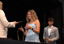 Senior crosses stage and receives plaque during ceremony.