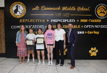 Award recipients, presenters and principal Dr. Larson pose with awards in CMS lobby.