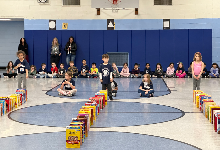 Cereal boxes are lined up like dominoes in the gymnasium, waiting to be toppled.