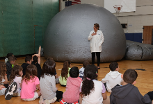 Long Island Science Center visitor speaks with students.