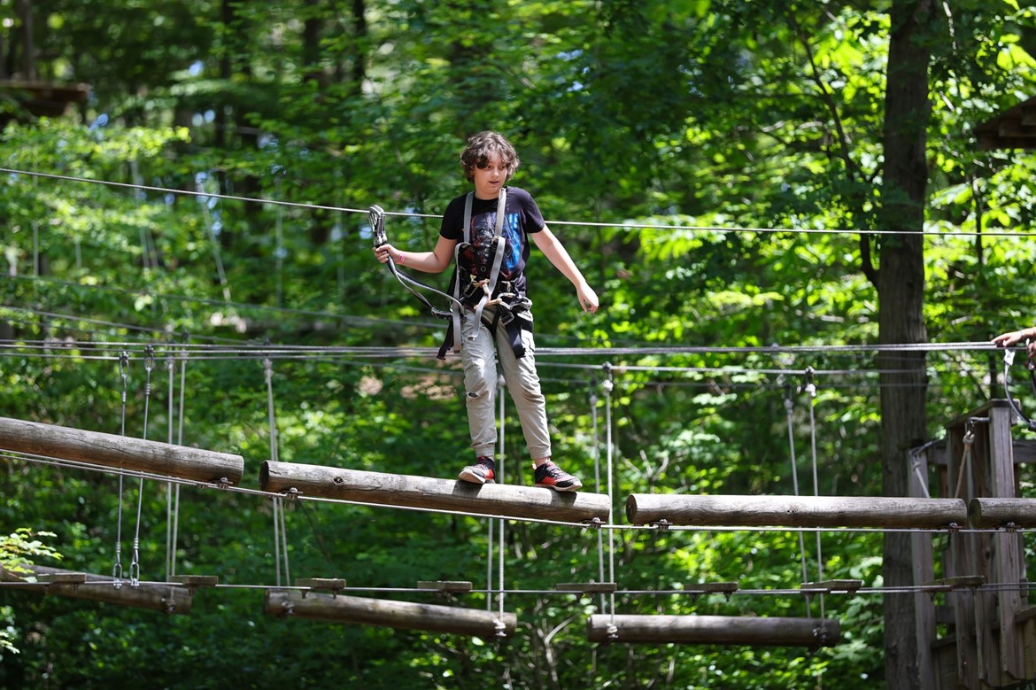 Burr fifth grade student navigates the ropes course during a field trip to Adventure Park.