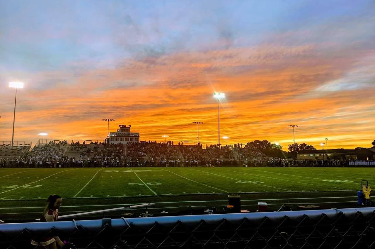 A picture of a sunrise over an athletic field