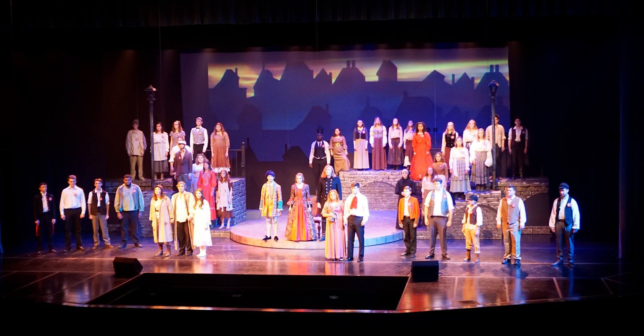 A stage of actors looks out on the crowd