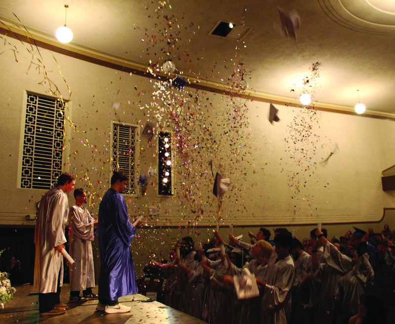 Graduates from Destinations Academy and Resource Link Charter School celebrate by throwing their caps and shooting off poppers at the end of their graduation ceremony Thursday.