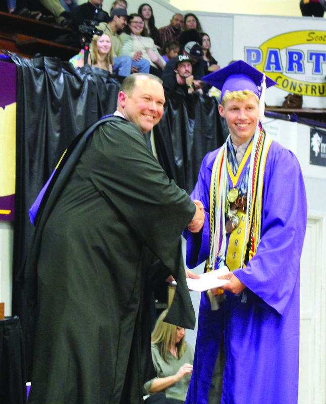 Jack Waddington accepts his diplomas from Principal Eli Ashton.