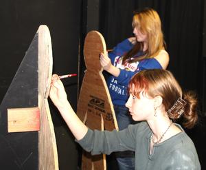 Ellajane Brigham, front, and Gracelyn Hamner paint props while preparing a haunted house that will open in the Marshfield High School Drama Lab on Friday.