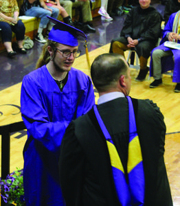 Jason Snyder accepts his diploma from Principal Eli Ashton.