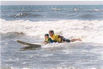 Rhame Avenue School students surfing with instructors. thumbnail260360