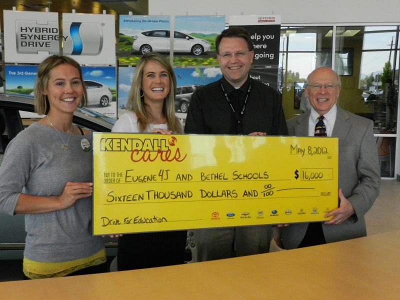 Kendall's Amy Newport and Shanley Skillern present a check to Bethel and 4J superintendents Colt Gill and Shelley Berman.