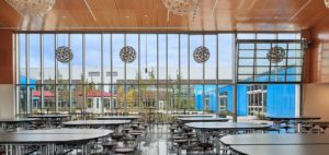 The new Roosevelt Middle School building's cafeteria overlooks a welcoming courtyard and opens to outdoor spaces when the weather allows. Photo courtesy of Mahlum Architects Inc.