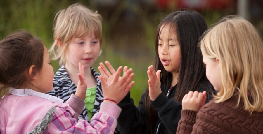 4J elementary school students play a hand-clapping game at recess