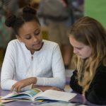 Image of two girls reading together in Eugene School District 4J elementary school in 2018. (Photo by Chris Pietsch)