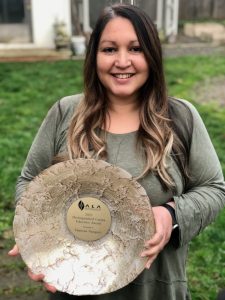 4J interpretation and translation coordinator Vanessa Vasquez holds her award