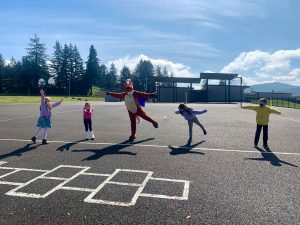 Students and staff on hard play area at recess