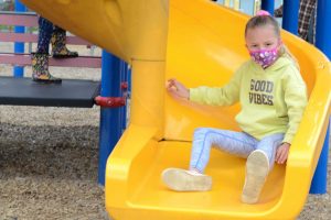 Student playing on playground at recess, following health and safety protocols