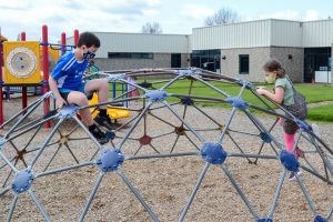 Students play on playground at recess, following health and safety protocols