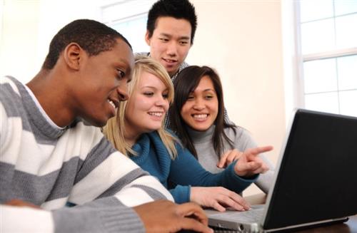 Students gathered around a laptop 