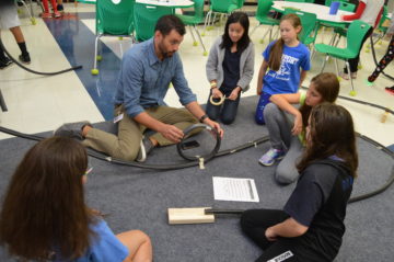 Teacher confers with students on project