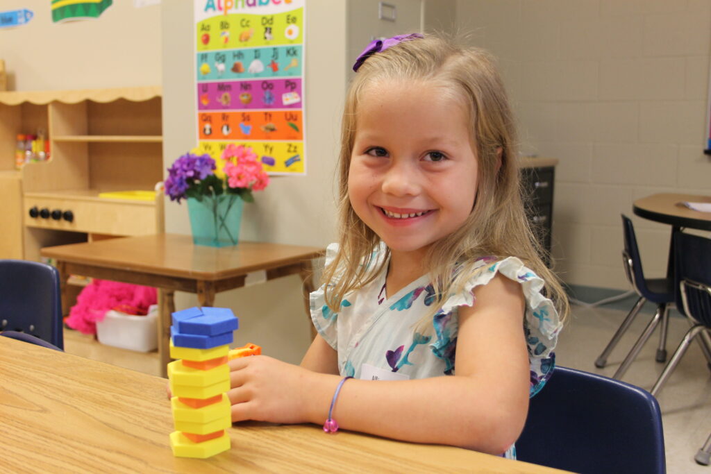 A young girl smiles toward the camera