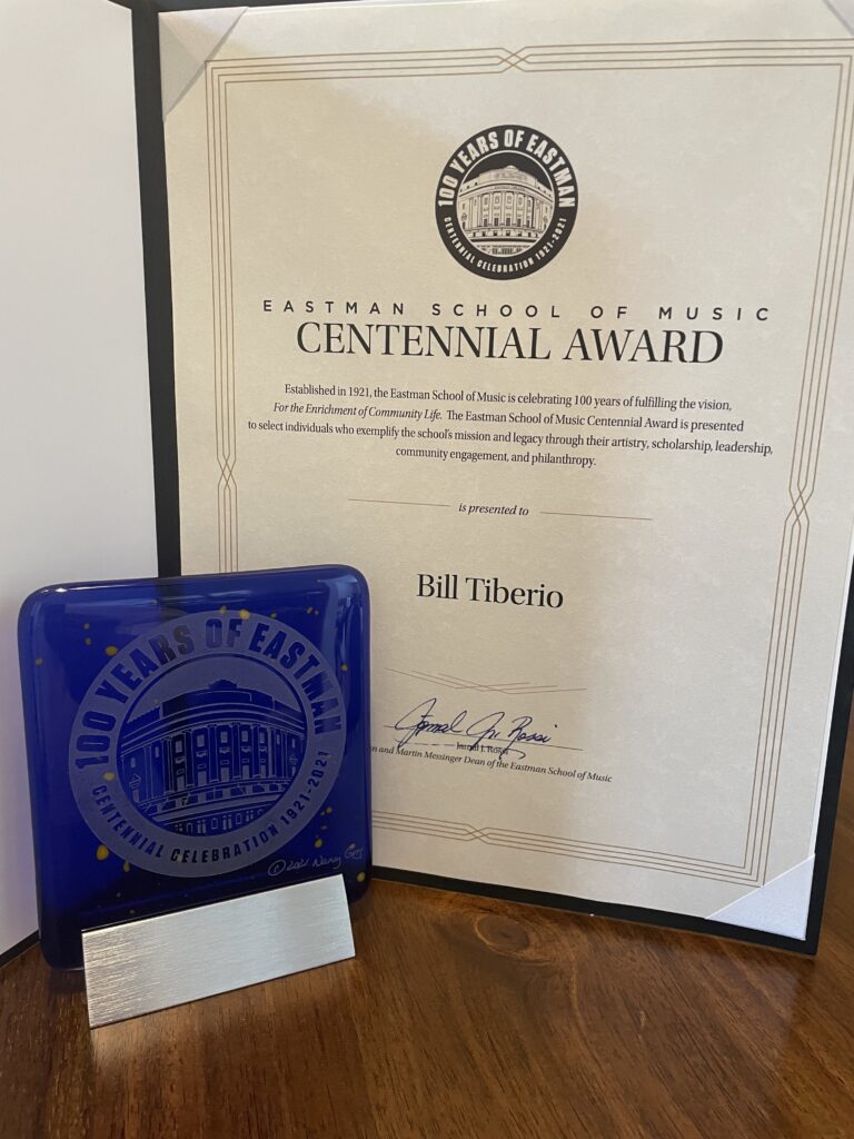 A blue glass award displayed next to an award certificate