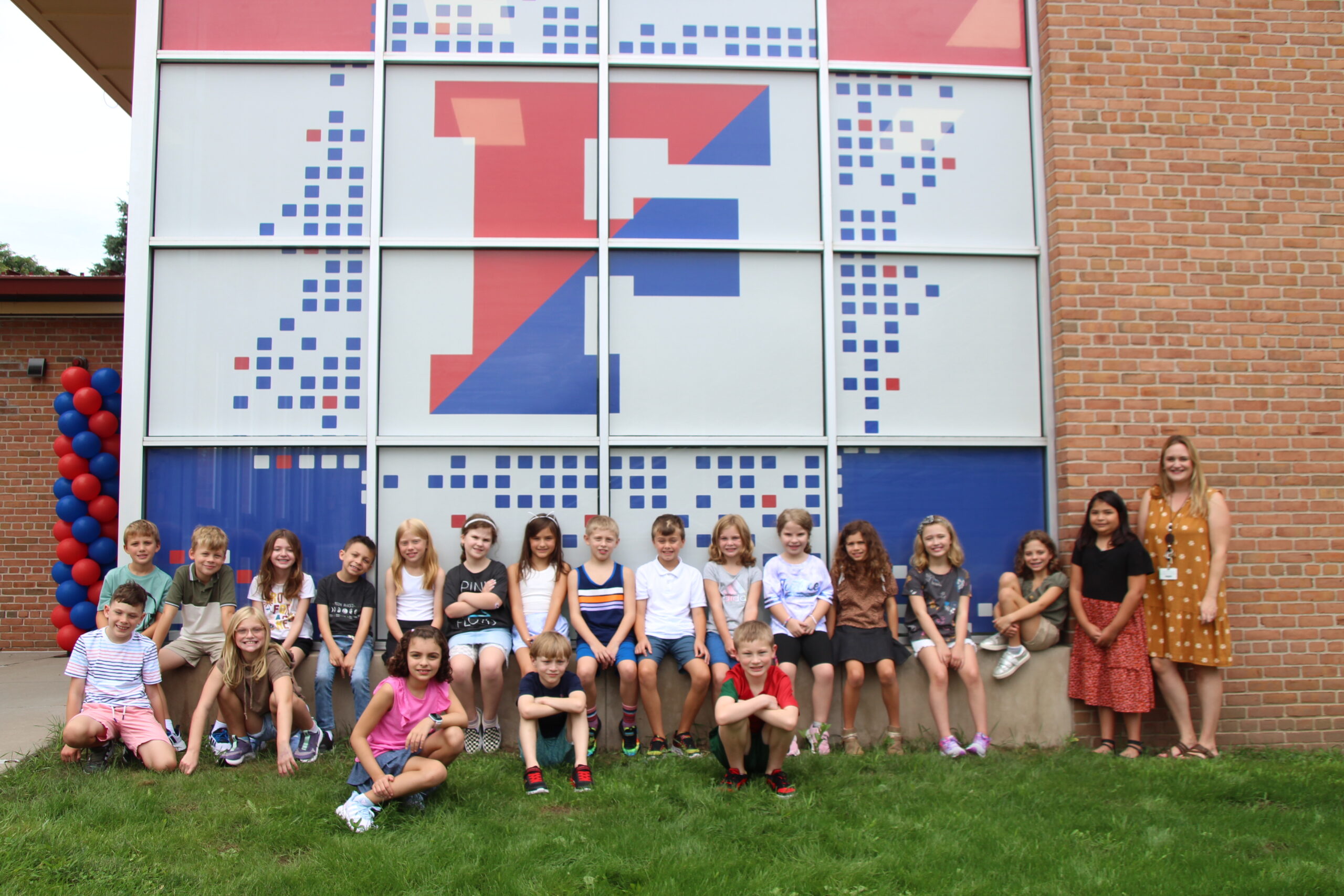 A group of elementary school students gathered outside their school building