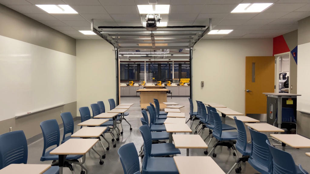 A classroom with rows of blue chairs and desks