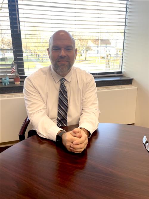 Mr. English sitting at a table infront of window