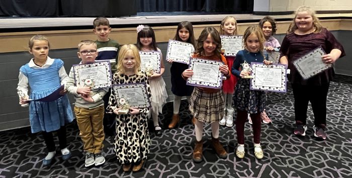 Fremont City Schools 1st grade students in the Fremont Ross High School Performing Arts Center in front of the stage posing with awards.  