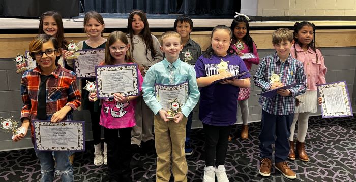 Fremont City Schools 2nd grade students in the Fremont Ross High School Performing Arts Center in front of the stage posing with awards.  