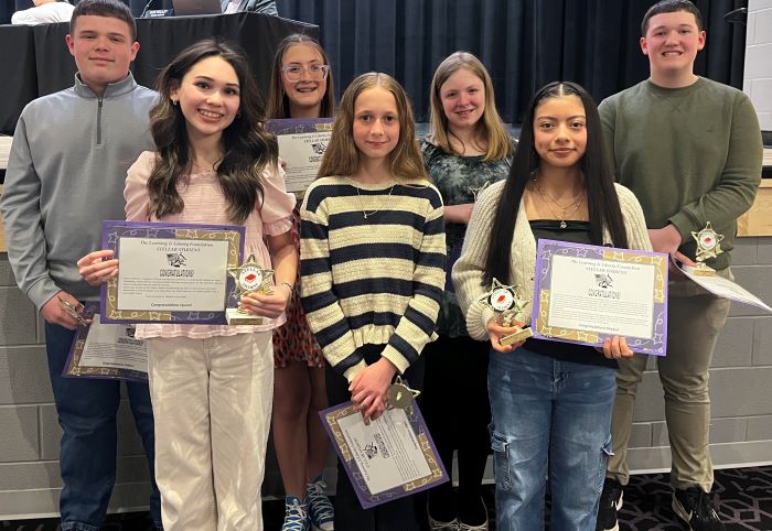 Fremont City Schools 6th-8th grade students in the Fremont Ross High School Performing Arts Center in front of the stage posing with awards.  