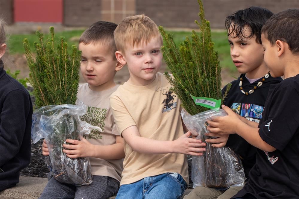  Student holds a bag of saplings