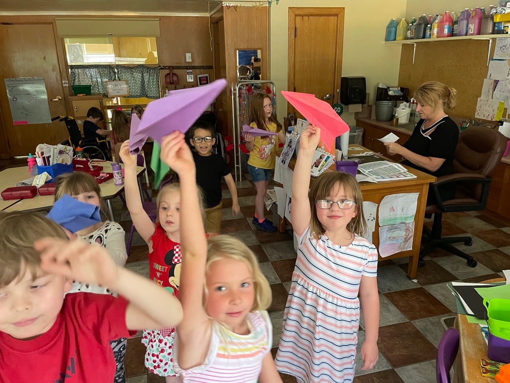 students playing with their paper airplanes